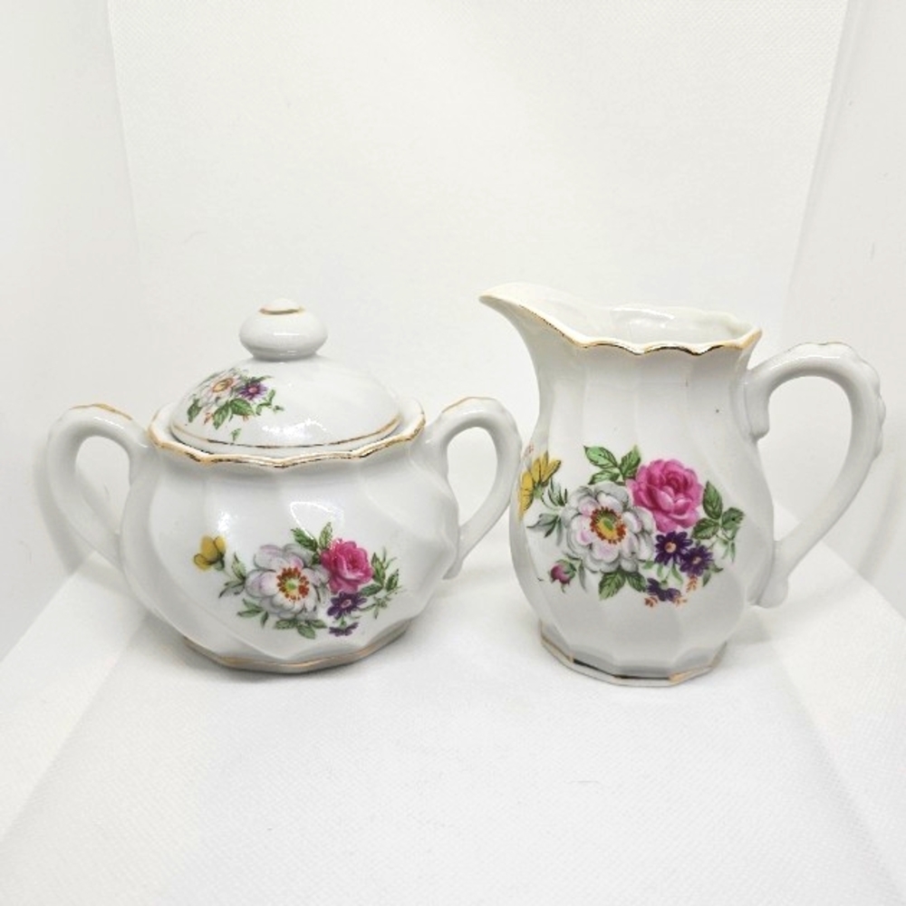 A vintage creamer and sugar bowl set, manufactured in Japan, with a lid.